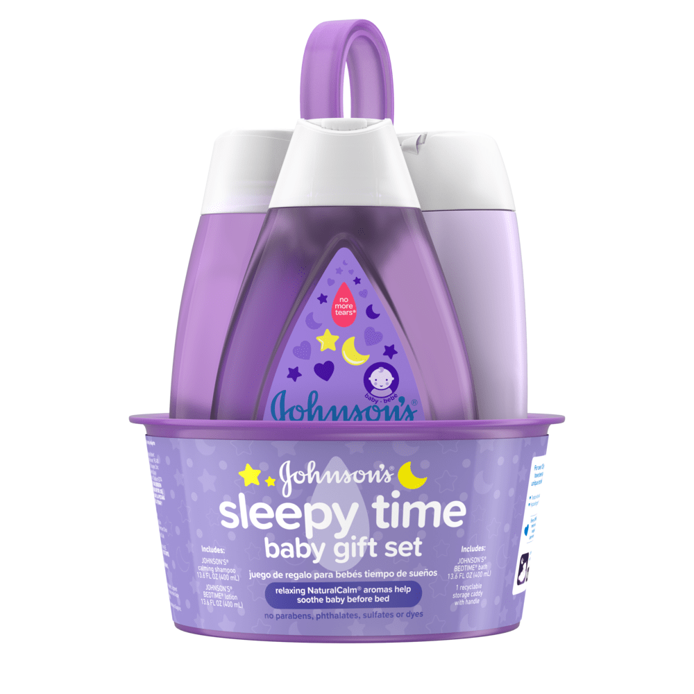 Un juego de regalo morado contiene tres productos para el cuidado del bebé con el texto "Johnson's sleepy time baby gift set" en el frente. Los envases se colocan en una bandeja a juego con un asa de transporte.