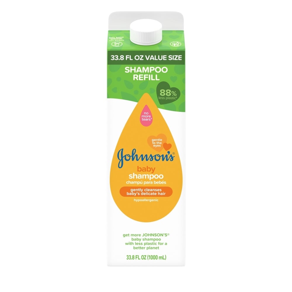 Una caja de cartón blanca y verde de 33.8 FL OZ con la etiqueta "SHAMPOO REFILL" contiene champú para bebé Johnson's. El texto incluye "88% menos de plástico", "No More Tears", "limpia suavemente el delicado cabello del bebé" y "1000 mL".