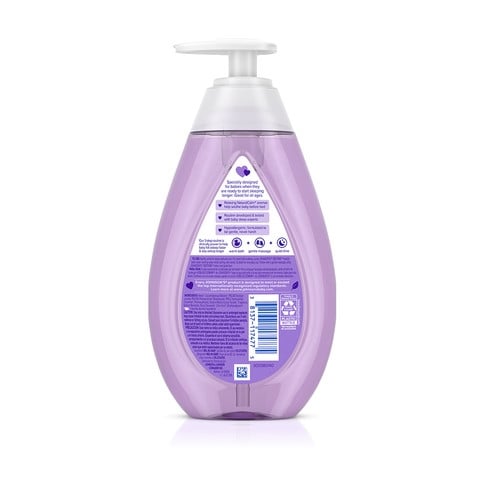 Un envase de plástico púrpura con dispensador contiene champú para bebé de Johnson's, etiquetado como "lavanda calmante" y "No More Tears". El fondo es blanco liso.