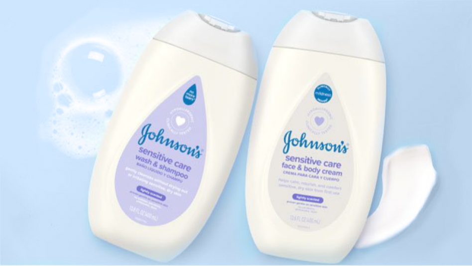 Dos frascos de productos Sensitive Care Johnson's sobre un fondo azul claro con burbujas. Un frasco es jabón líquido y champú, y el otro, crema facial y corporal, ambos de 16,9 fl oz (500 ml) con tapa blanca y etiqueta morada.