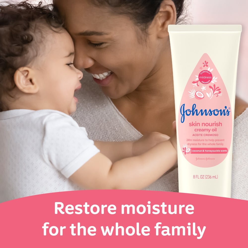 Una madre y su bebé se miran el uno al otro, sonriendo. Un envase de aceite cremoso Johnson's Skin Nourish con aroma de coco y madreselva ocupa un lugar destacado. El texto dice: "Restaura la humectación para toda la familia".