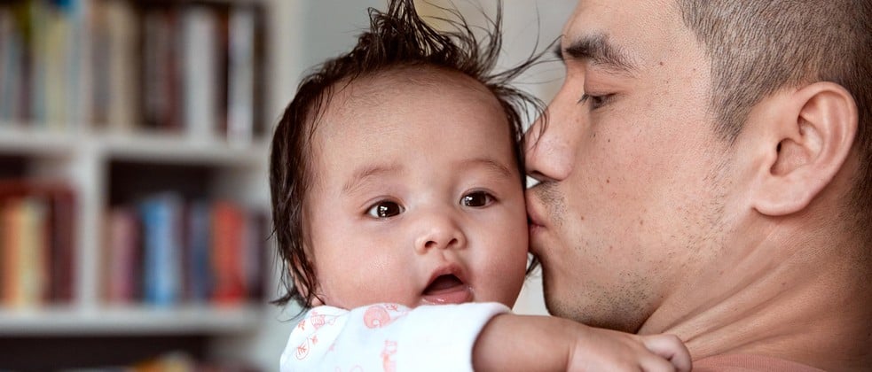 Papá besa al bebé después de la hora del baño